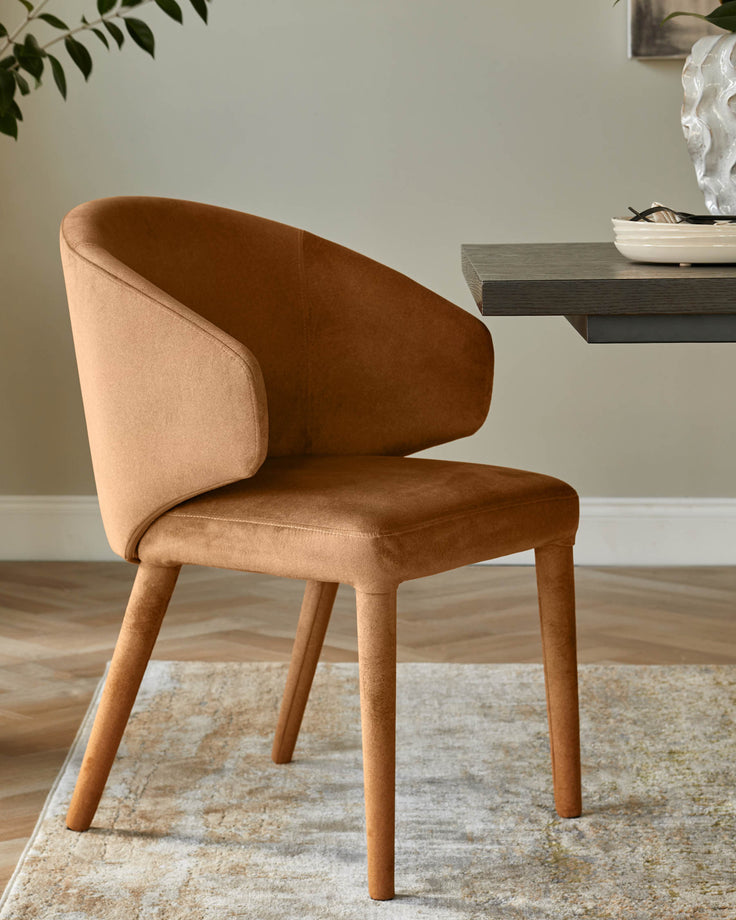 A stylish brown chair with curved armrests sits beside a dark wood table, atop a patterned rug in a modern interior.