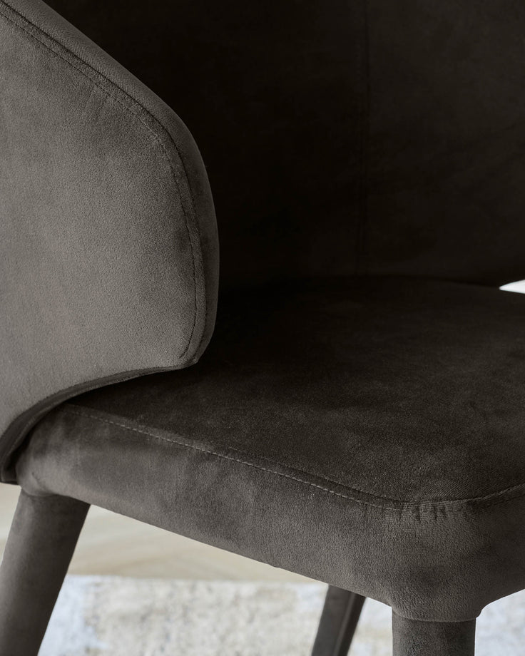 Close-up of a stylish brown upholstered chair with arms. Perfect for adding a touch of elegance to any dining space.