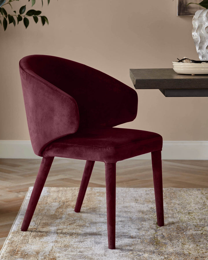 Ethan dining chair in plum velvet with curved backrest and four wooden legs, positioned at an angle on a neutral area rug.