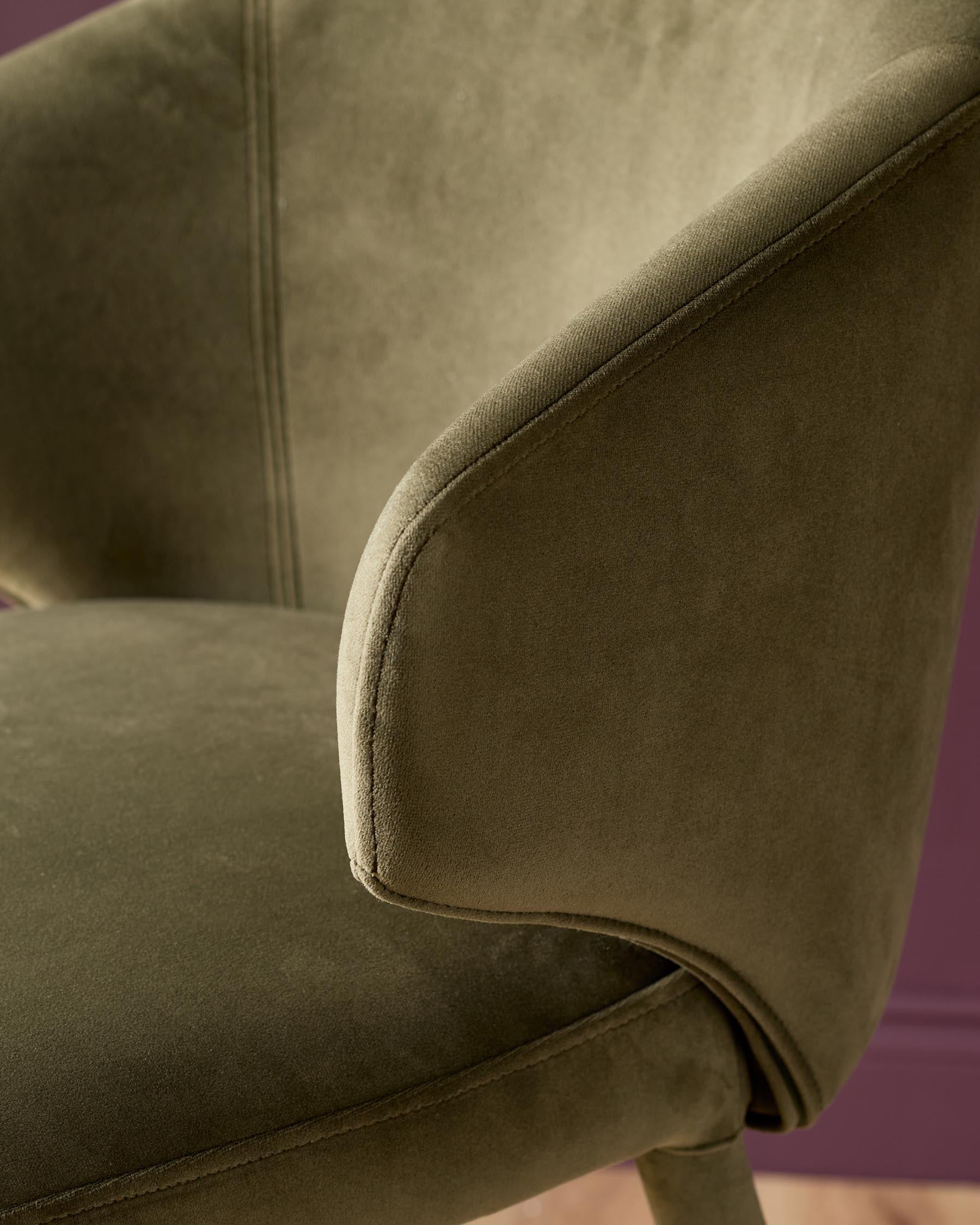 Ethan bar stool in olive green velvet, close-up detail of curved armrest and stitching.