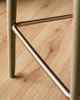 Ethan bar stool in olive green velvet with brushed metal footrest and leg detail on wooden floor.