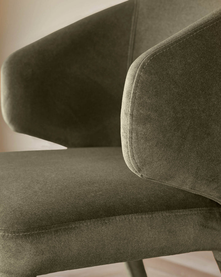 Close-up of a stylish olive green armchair, showcasing its textured fabric and cushioned armrest.