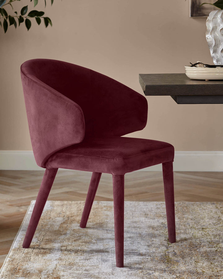 Plum velvet dining chair with curved backrest and four wooden legs, positioned at an angle in a styled room setting.