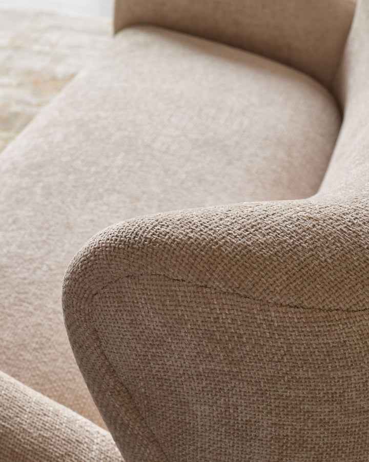 Close-up detail of natural beige fabric upholstery on Evelyn 2-seater sofa, showing textured weave and curved armrest.