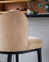 Evelyn bar stool in champagne velvet with black wooden legs, side view showing curved backrest and seat detail.