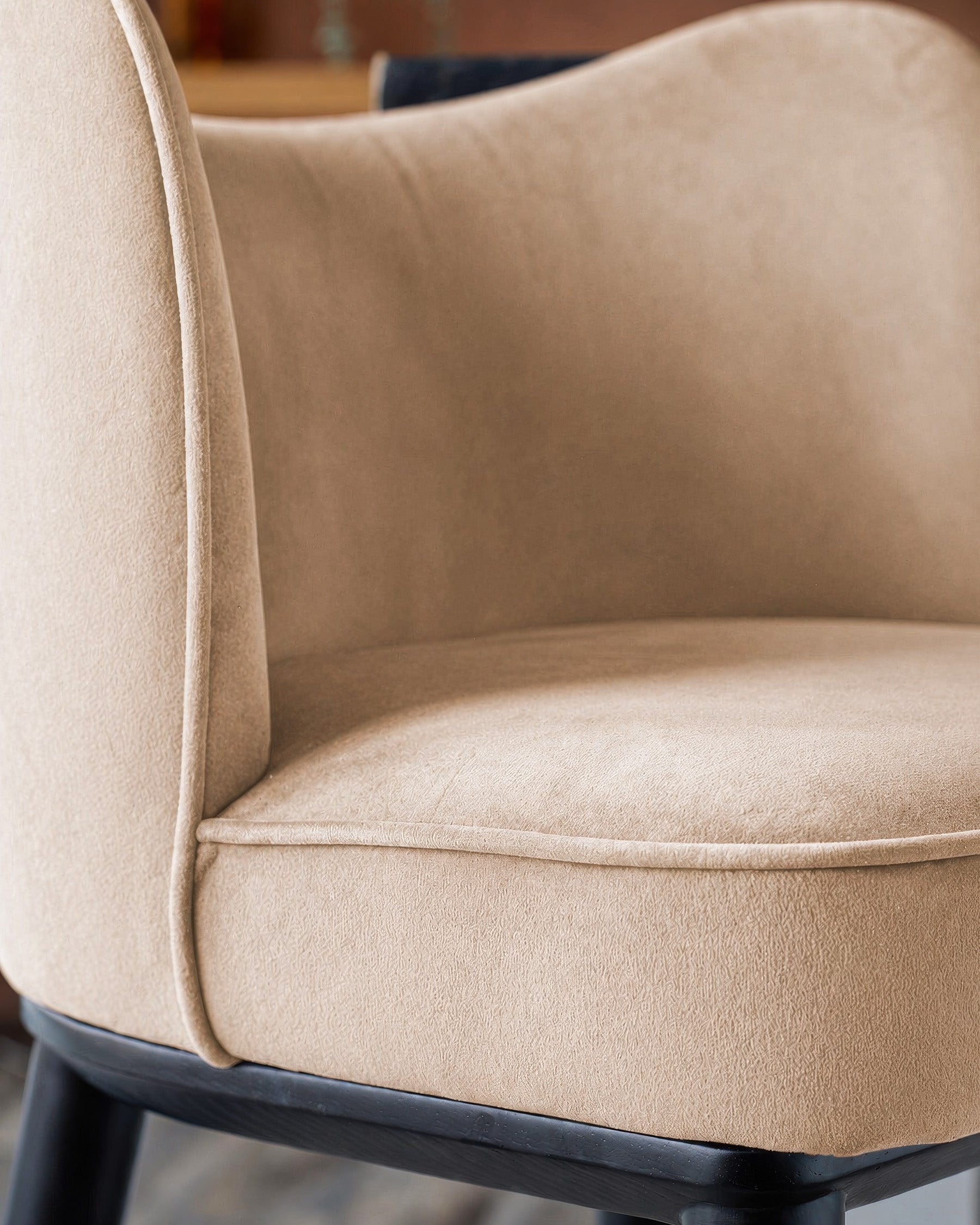 Evelyn bar stool in champagne velvet with black wood base, close-up of seat and backrest detail.