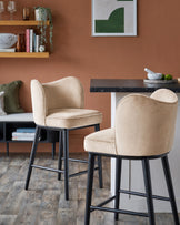 Evelyn bar stool in champagne velvet with black wood legs, shown in a styled interior setting.