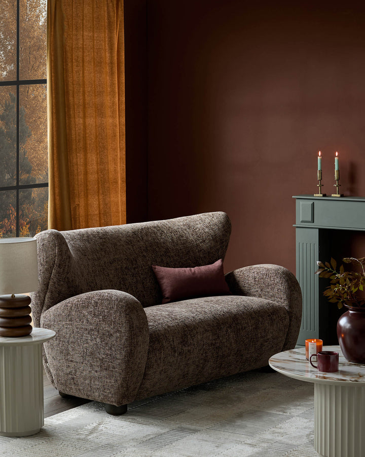 Evelyn 2-seater sofa in mocha fabric with curved armrests and rounded silhouette, styled in a warm interior setting.