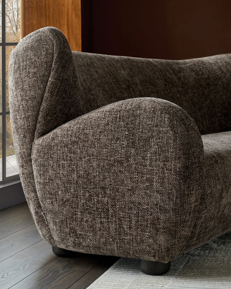 Evelyn 2-seater sofa in mocha fabric, side view showing curved armrest and rounded cushioning with dark feet.