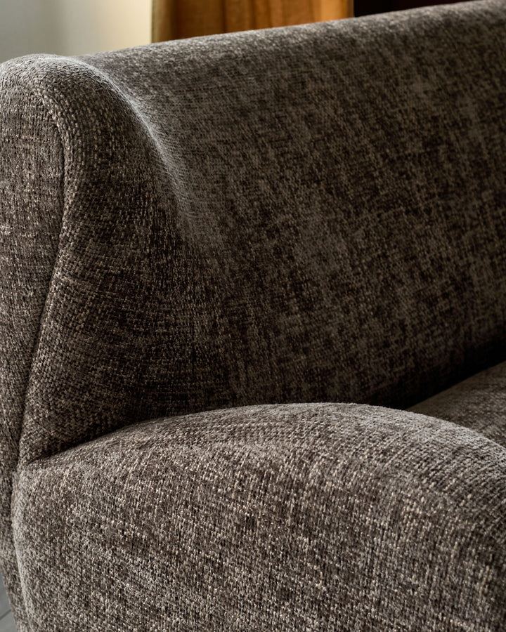 Close-up of mocha fabric upholstery showing textured weave and curved armrest of the Evelyn 3-seater sofa.