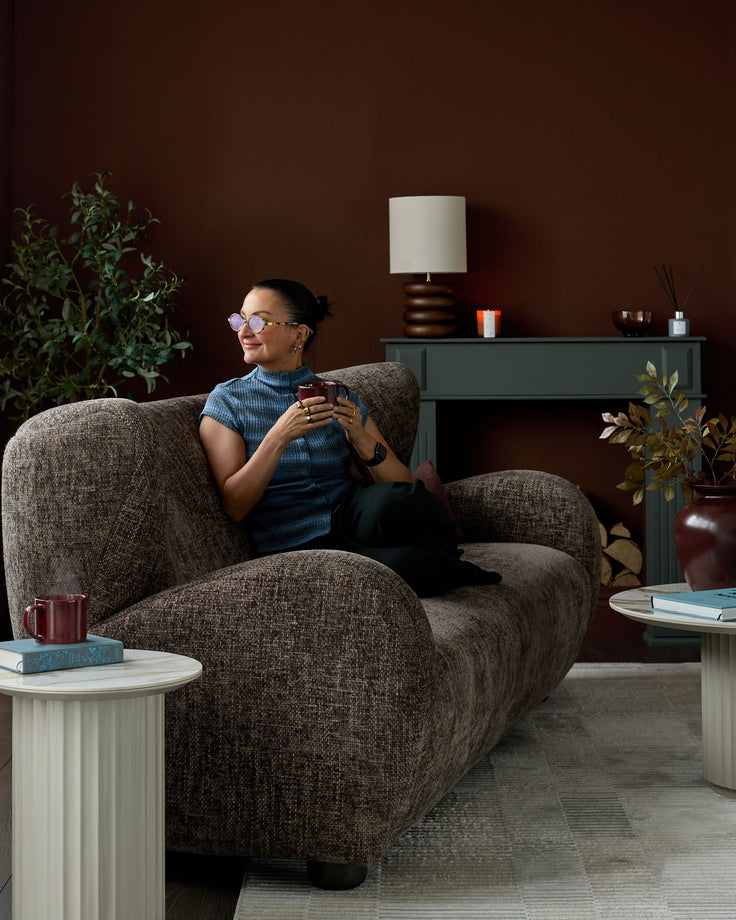 Mocha fabric three-seater sofa with curved, rounded arms in a styled living room setting.