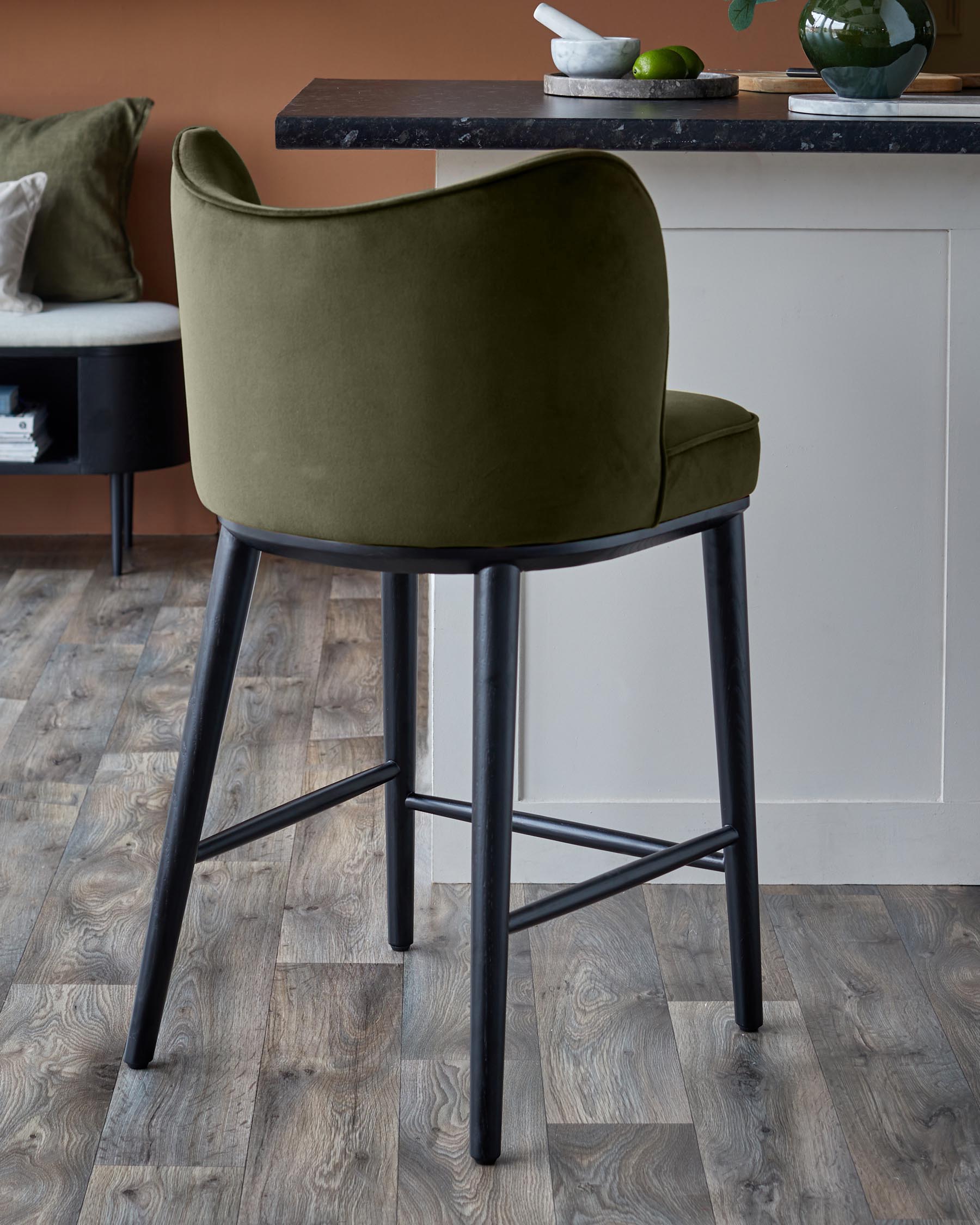 An olive green bar stool with black legs, set against a neutral backdrop, complements the kitchen decor.