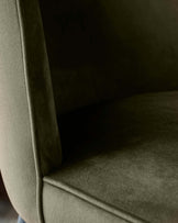 Close-up of an olive green armchair, showcasing its textured upholstery and curved frame.