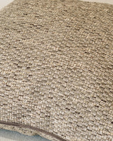 Large natural linen cushion with textured woven fabric and visible stitching detail along the edge.