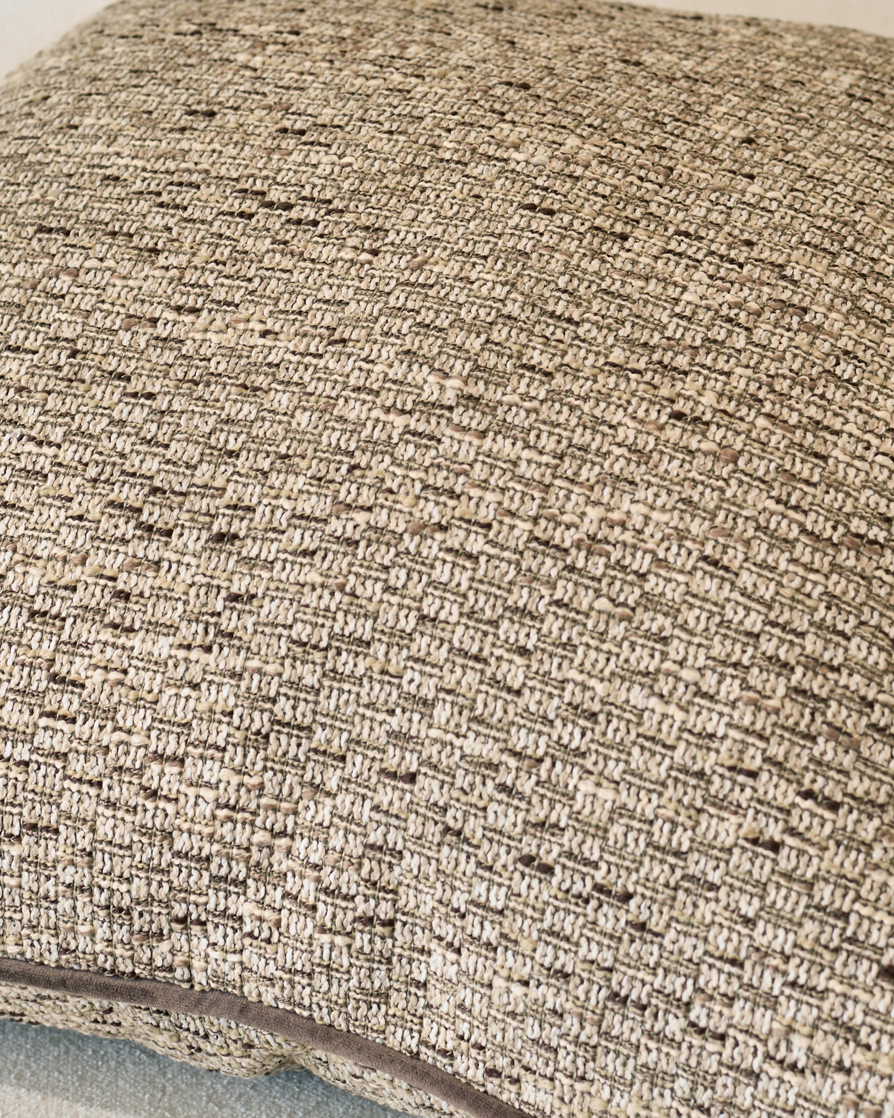 Large natural linen cushion with textured woven fabric and visible stitching detail along the edge.
