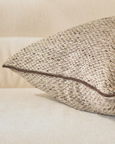 Fabian large cushion in natural beige, showing textured woven fabric detail from a side angle.