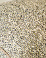 Close-up of Fabian large green cushion showing textured woven fabric with neutral and blue-toned yarns in a basket weave pattern.