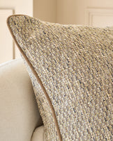 Fabian large green cushion with textured woven fabric, displayed at an angle on a neutral upholstered chair.
