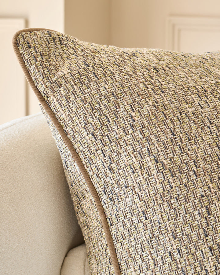 Fabian large green cushion with textured woven fabric, displayed at an angle on a neutral upholstered chair.