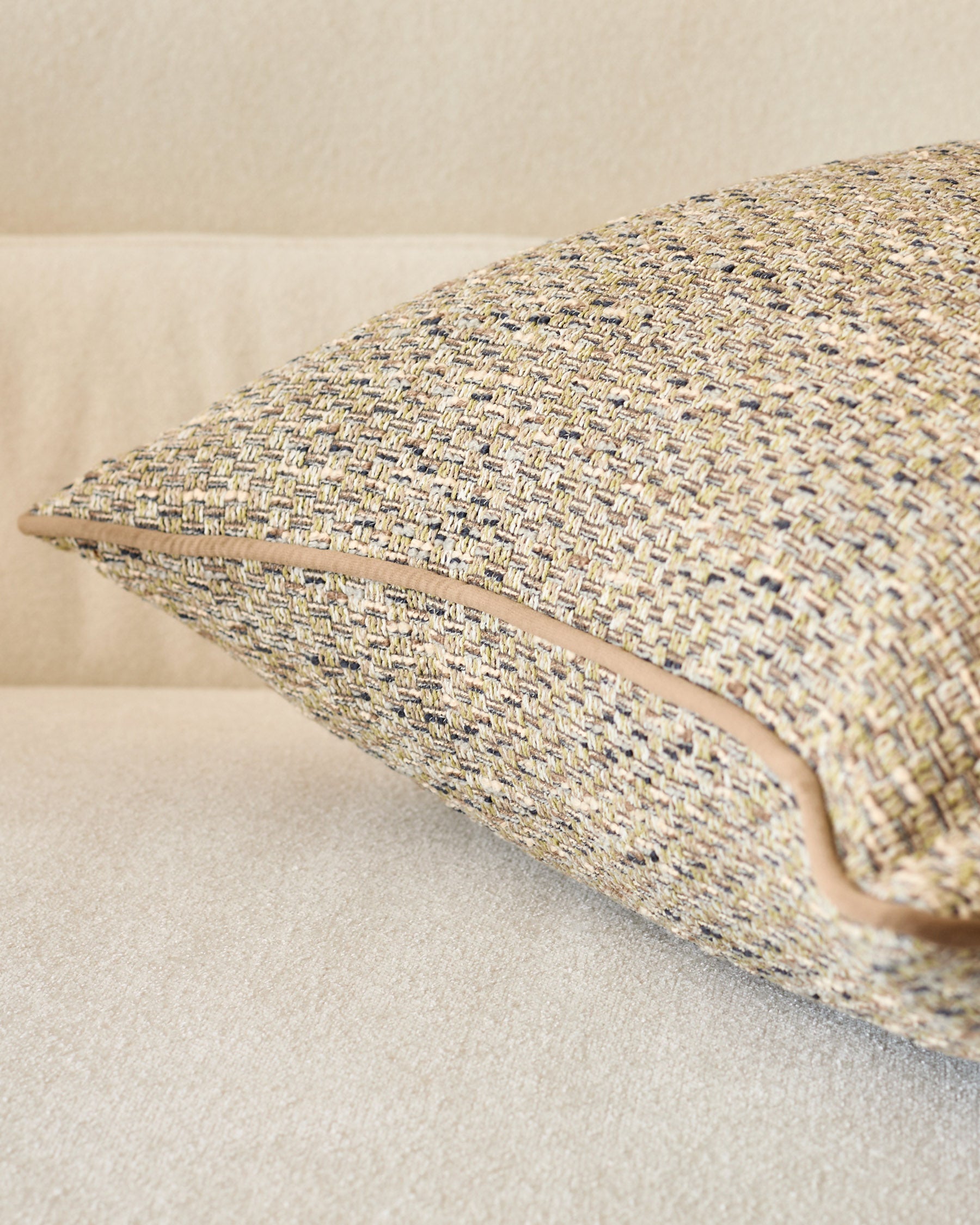 Fabian cushion in large size with green-toned woven texture, displayed at an angle showing its plump form and woven fabric detail.