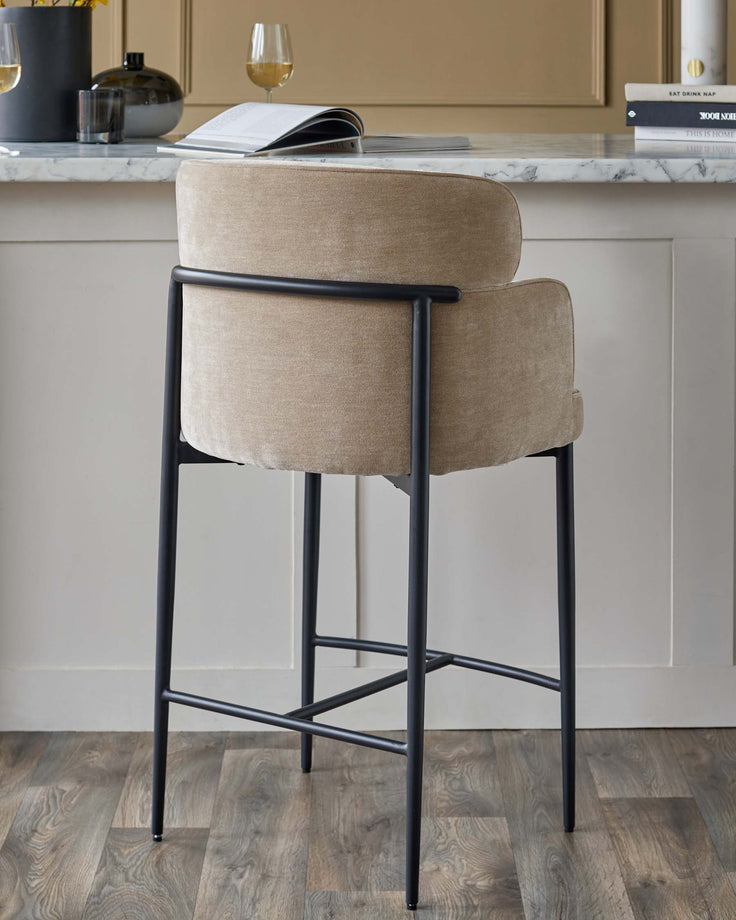 A stylish bar stool with a cushioned seat and sleek black frame. Perfect for modern kitchens and dining areas.