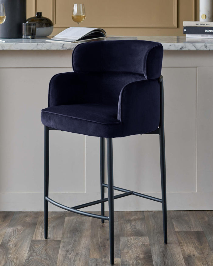 Navy velvet bar stool with arms and black metal frame. Stylish seating for your kitchen or bar area.