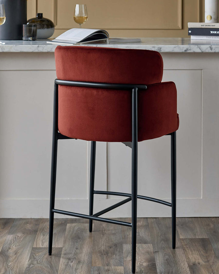 A stylish, modern bar stool in burnt orange velvet with a black metal frame. Perfect for adding a pop of colour to your kitchen.