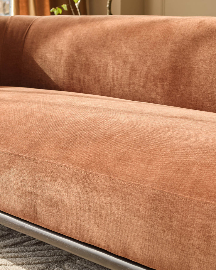 Florence left-hand corner sofa in apricot fabric with dark wood base, shown at close angle highlighting seat cushion detail.