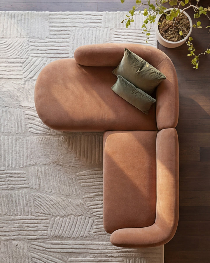Florence left-hand chaise sofa in apricot fabric, shown from above with olive pillows, on textured cream rug.