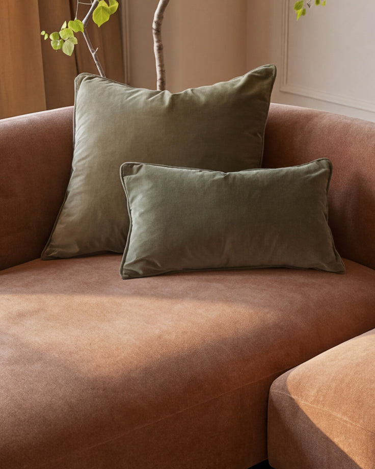 Florence left-hand corner sofa in apricot fabric with sage green piping detail cushions and wooden legs, styled with potted plant.