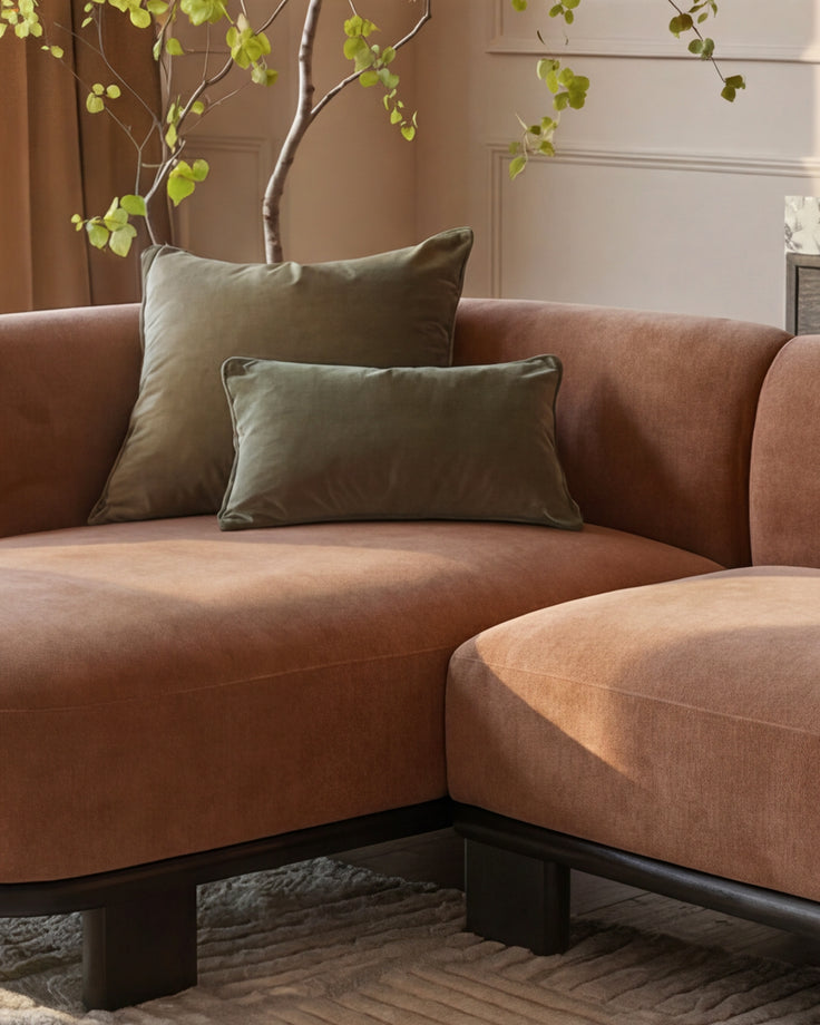 Florence left-hand-facing chaise sofa in apricot fabric with dark wood base, styled with green cushions and decorative branches.