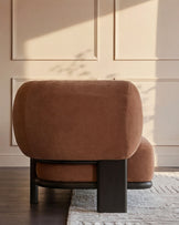 Apricot fabric chaise sofa with dark wood frame, curved design, shown from rear angle in sunlit room.