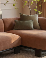 Florence right-hand facing chaise sofa in apricot fabric with dark wood base, styled with sage green pillows and decorative branches.