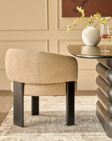 Florence dining chair in honey fabric with black wooden legs, shown in a styled room setting next to a round table.