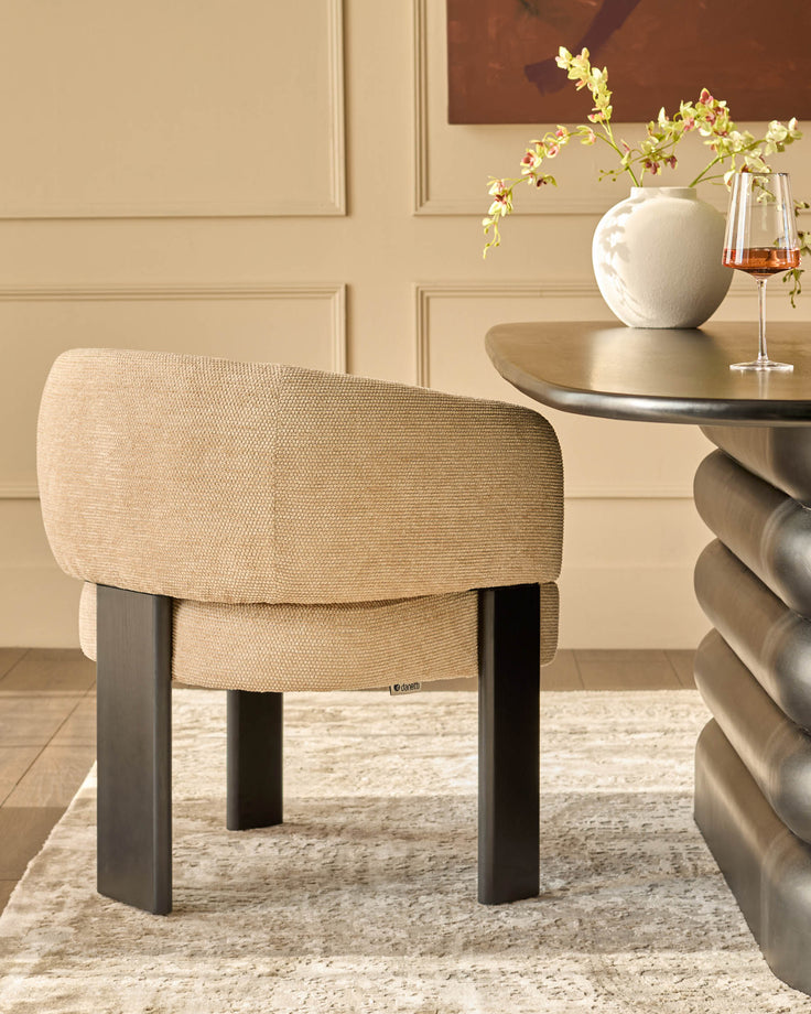 Florence dining chair in honey fabric with black wooden legs, shown in a styled room setting next to a round table.