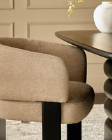 Florence dining chair in honey fabric, showing curved backrest and black wooden legs from a side angle.