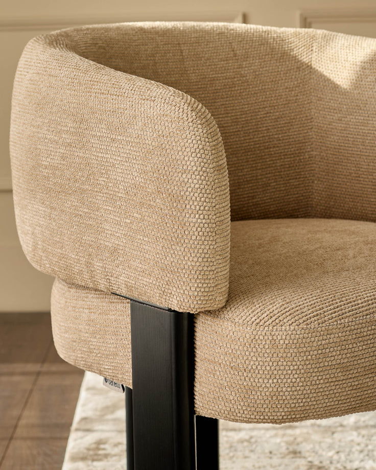 Florence dining chair in honey fabric, close-up detail showing textured weave and curved armrest with black wooden frame.