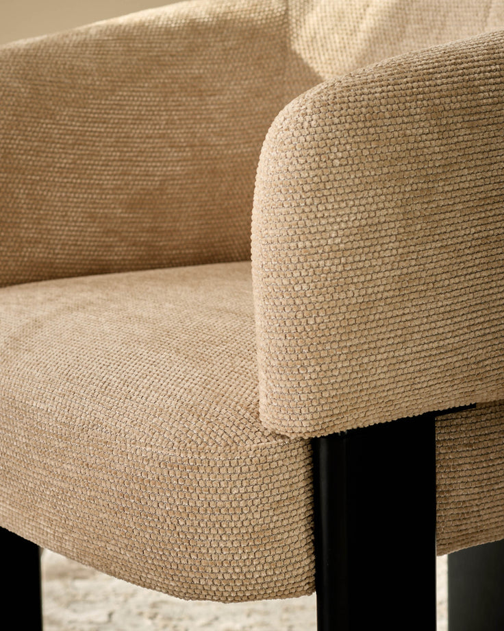 Florence Dining Chair in honey fabric, close-up of curved armrest and seat with textured weave detail and black leg.