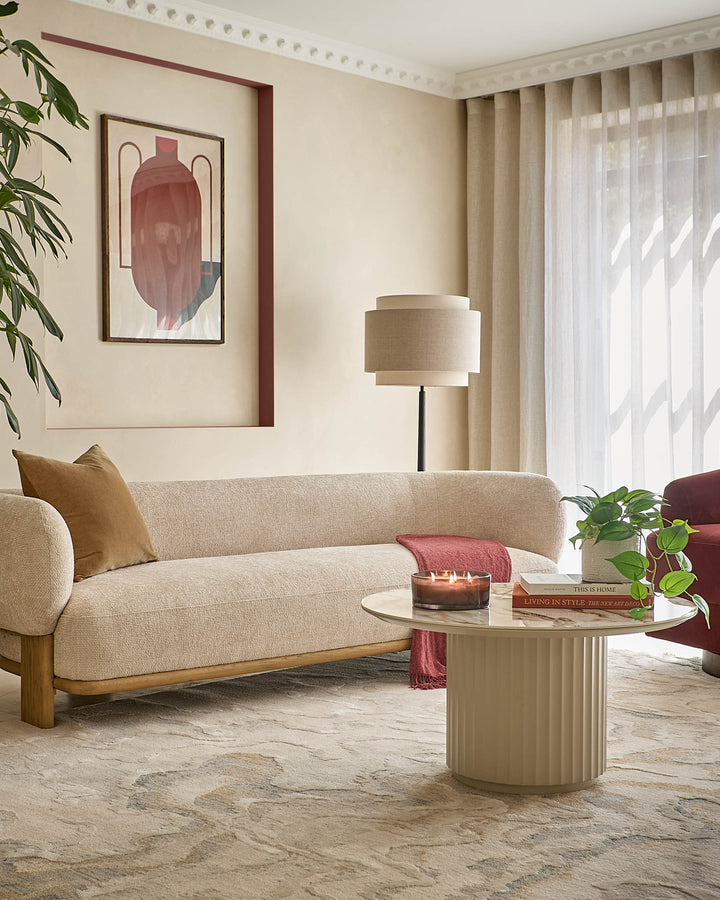 Large textured silver rug in modern living room with cream sofa, round table, and floor lamp.