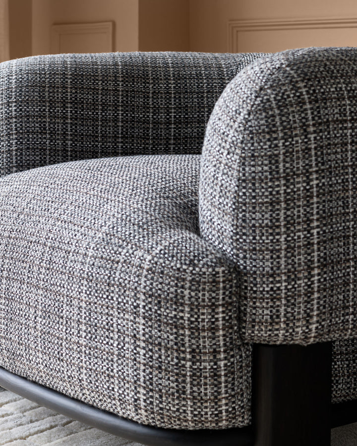 Florence armchair in dark chocolate weave fabric with curved arms and dark wood legs, close-up detail view.