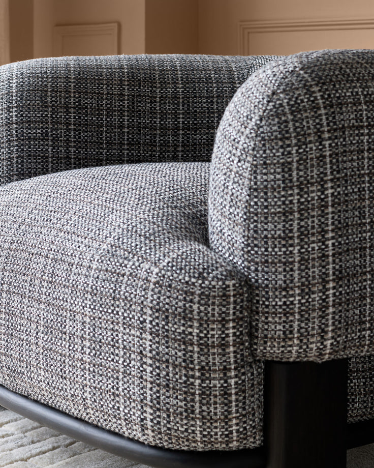 Florence armchair in dark chocolate weave fabric with curved arms and dark wood legs, close-up detail view.
