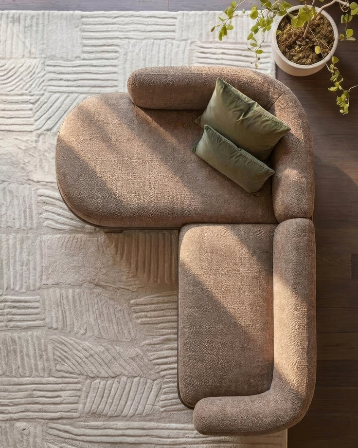 Florence left-hand facing chaise sofa in mocha fabric with green pillows, viewed from above on textured cream rug.