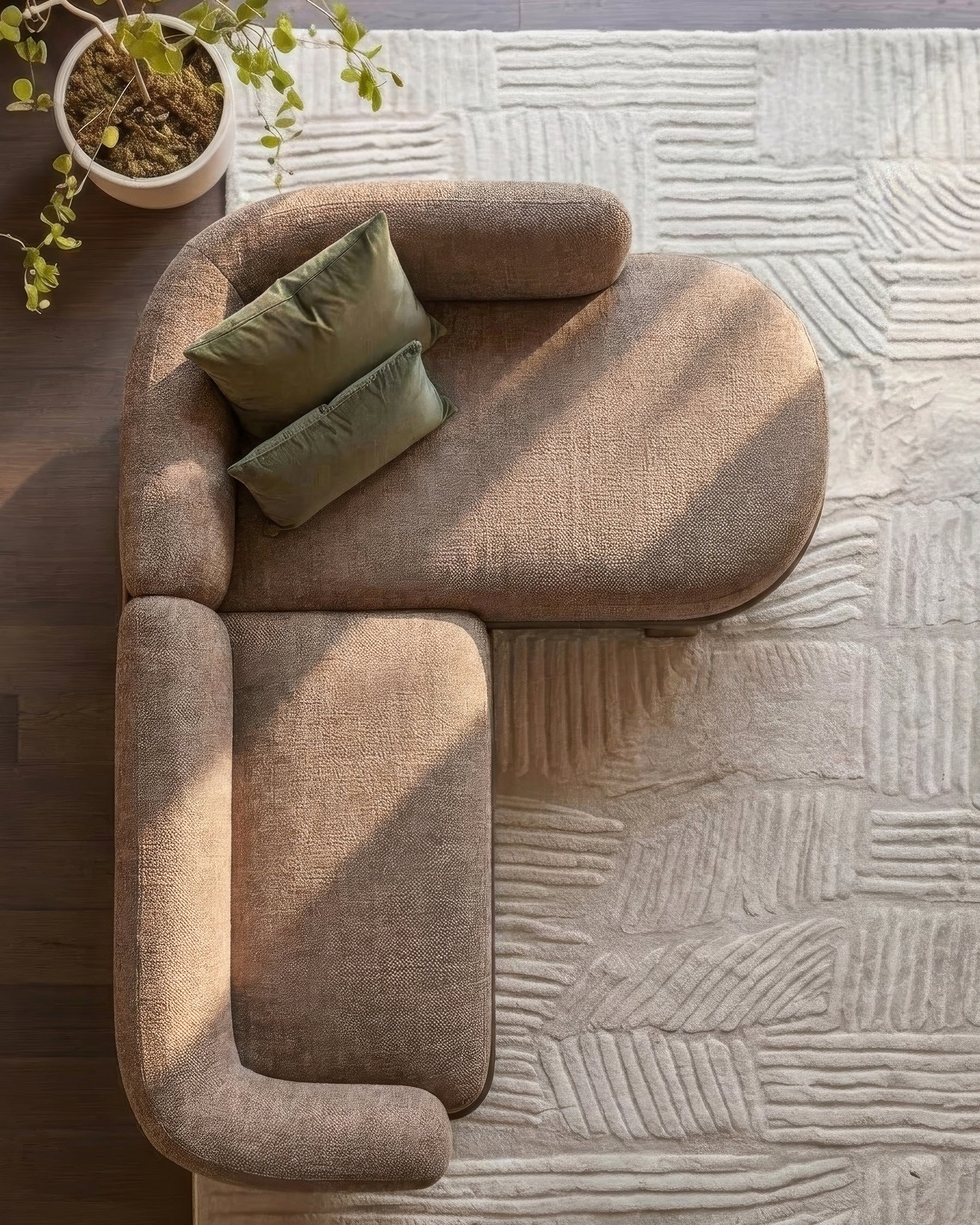 Florence right-hand-facing chaise sofa in mocha fabric with curved armrests, viewed from above on textured white area rug.