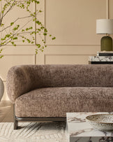 Florence 2-seater sofa in mocha fabric with dark wood base, curved arms, displayed in a styled living room setting.