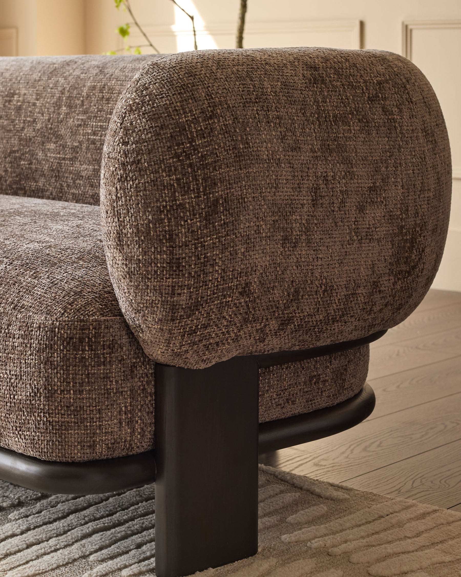 Florence 2-seater sofa in mocha fabric with curved armrest and dark wood base, side view detail.