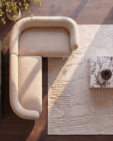 Cream fabric right-hand-facing corner sofa viewed from above, showcasing curved armrests and clean lines on wooden flooring.