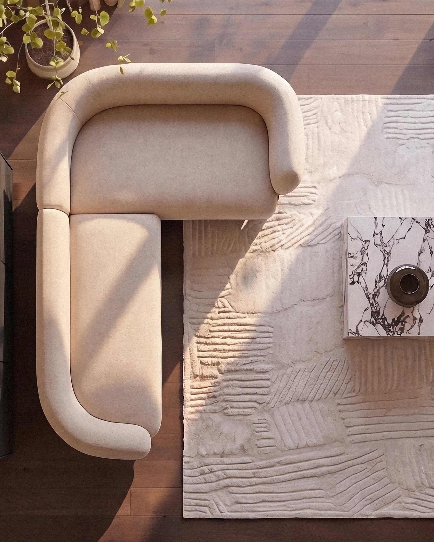 Cream fabric right-hand-facing corner sofa viewed from above, showcasing curved armrests and clean lines on wooden flooring.