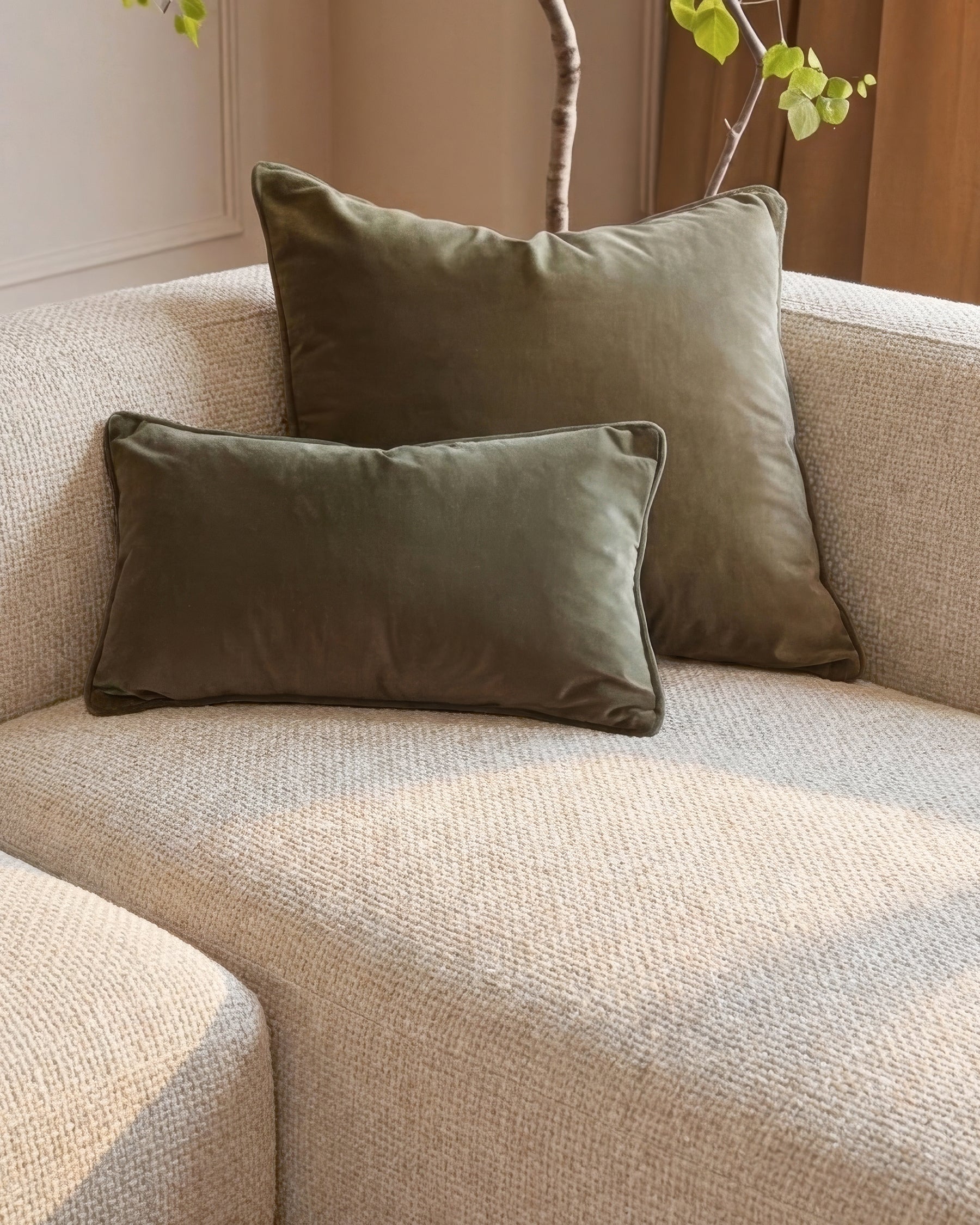 Florence right-hand chaise sofa in natural fabric with sage green piped pillows and decorative branches.