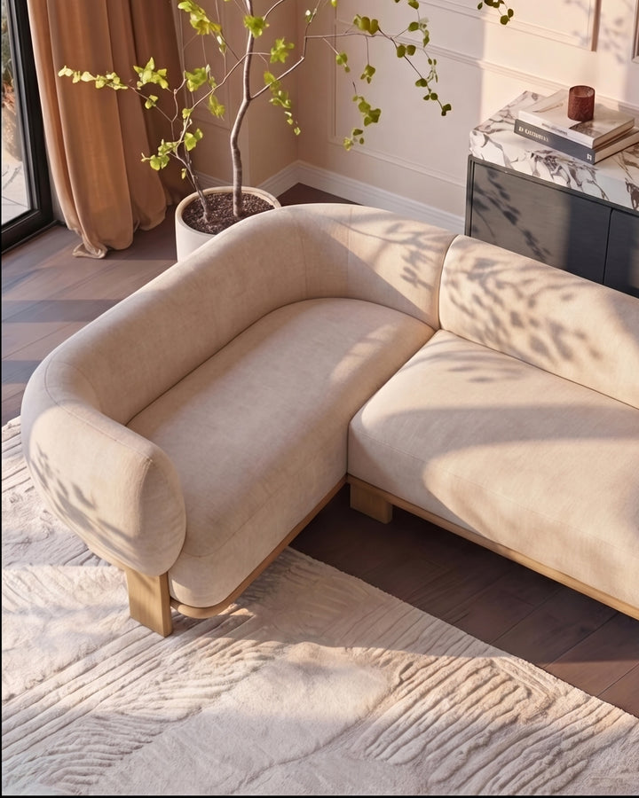Florence left-hand-facing small corner sofa in natural fabric with light wood legs, displayed in a bright living room setting.