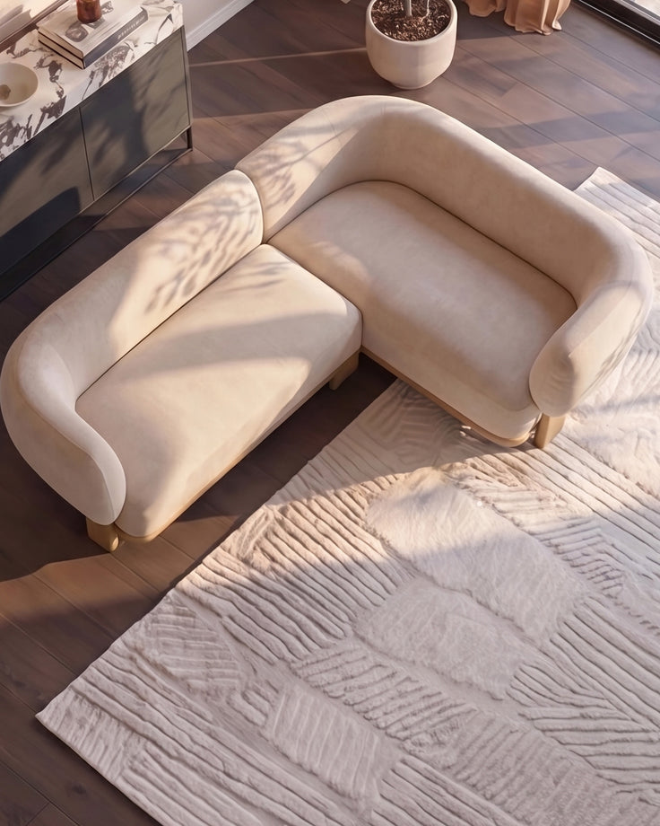 Florence right-hand-facing small corner sofa in natural fabric with light wood legs, shown in bright sunlight.